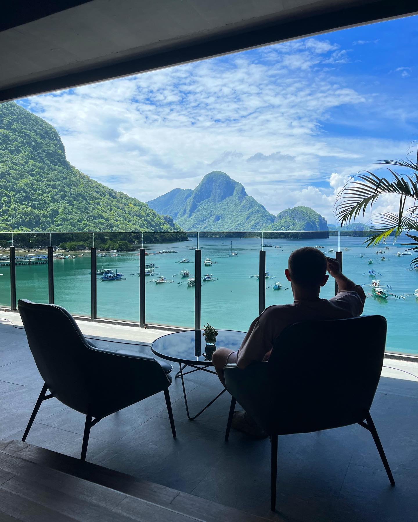 A man chilling in a balcony with island view of El Nido